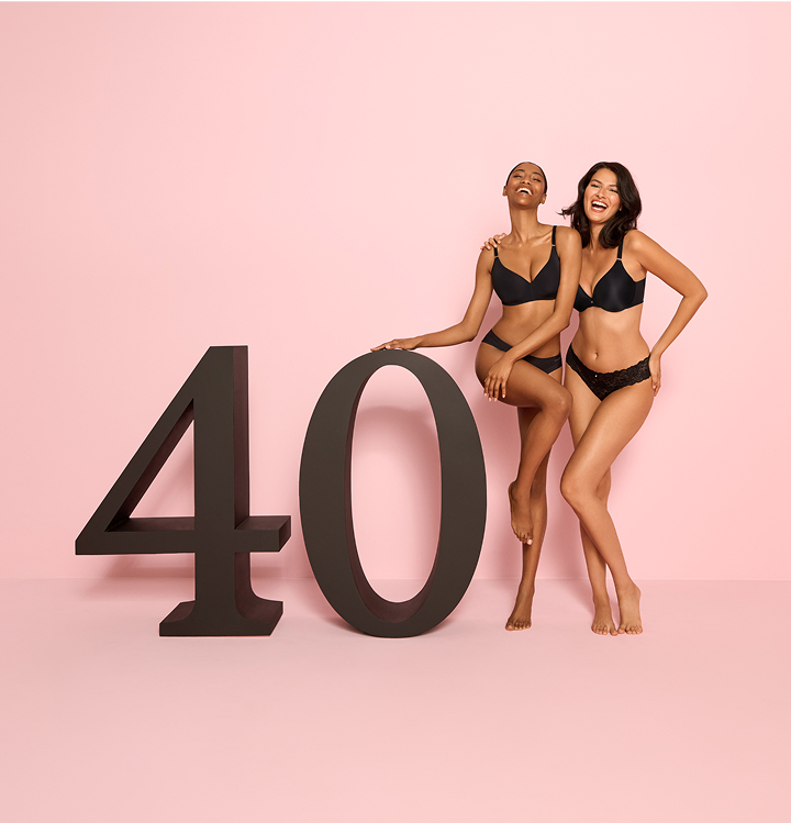 Deux mannequins v&ecirc;tus de soutiens-gorge et culottes noirs posant &agrave; c&ocirc;t&eacute; d&rsquo;un panneau &ldquo;40&rdquo; pour c&eacute;l&eacute;brer le 40e anniversaire de la la Vie en Rose