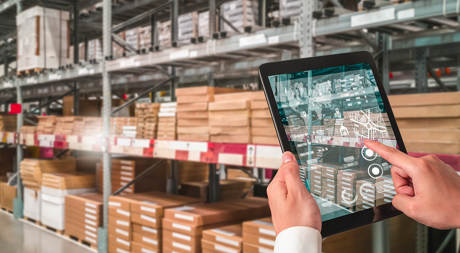 Employ&eacute; utilisant le nouveau syst&egrave;me ERP sur une tablette iPad lors de son travail dans l&rsquo;entrep&ocirc;t