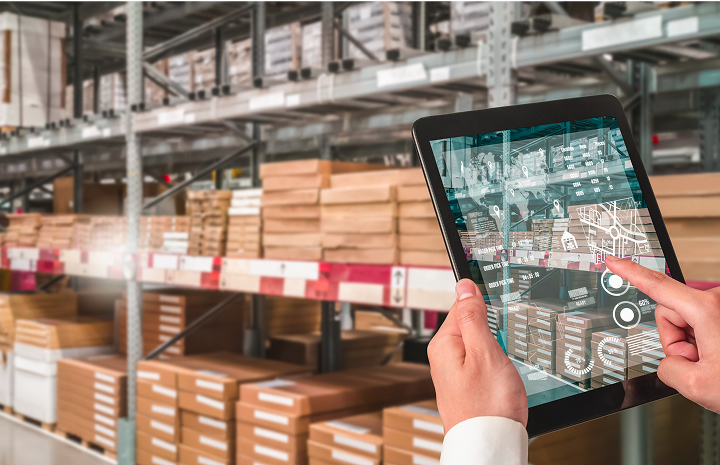 Employé utilisant le nouveau système ERP sur une tablette iPad lors de son travail dans l’entrepôt