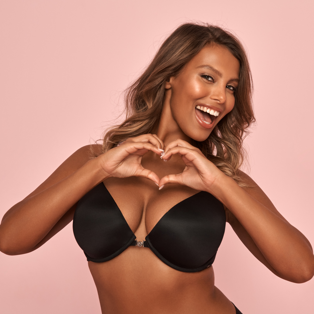 Mannequin portant un soutien-gorge noir, faisant un coeur avec ses mains.